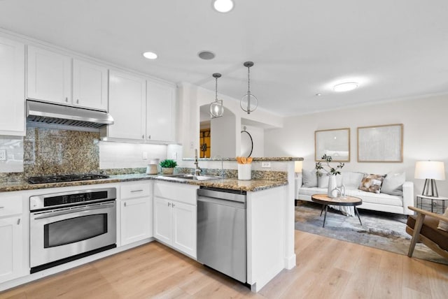 kitchen featuring hanging light fixtures, sink, white cabinets, and appliances with stainless steel finishes