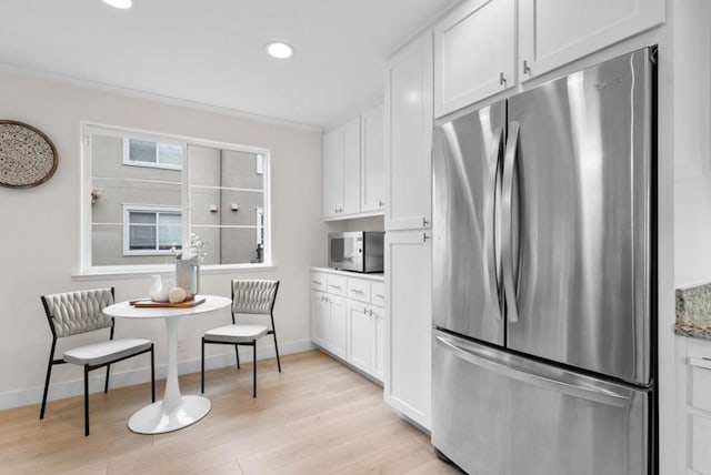 kitchen featuring stainless steel appliances, white cabinets, and light hardwood / wood-style floors