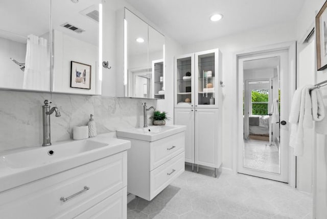 bathroom with vanity and tasteful backsplash