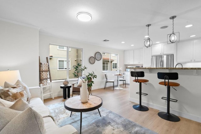 living room with crown molding and light wood-type flooring