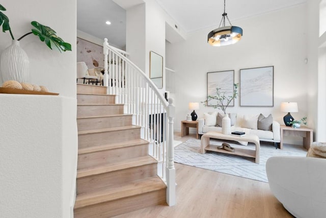 staircase featuring ornamental molding and hardwood / wood-style floors