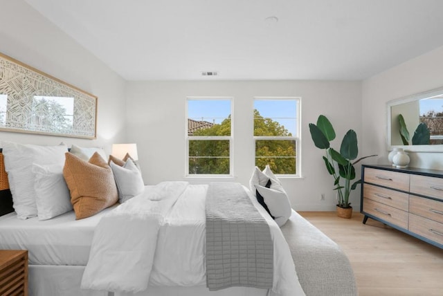 bedroom with multiple windows and light hardwood / wood-style floors