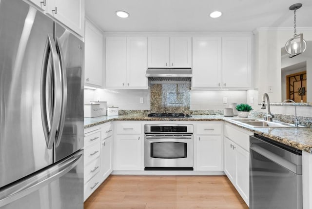 kitchen featuring stainless steel appliances, white cabinetry, sink, and stone counters