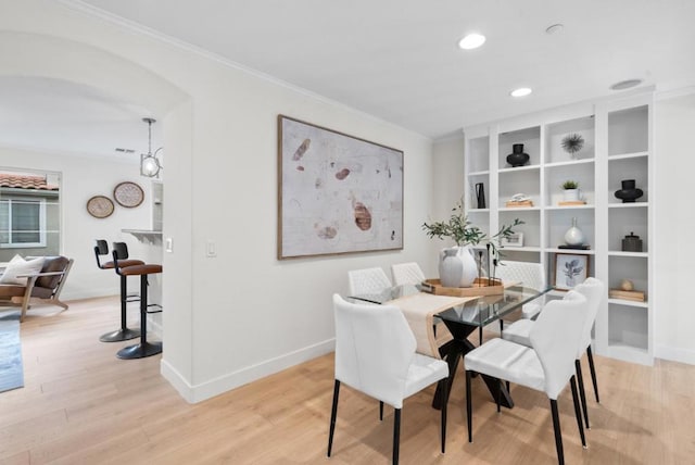 dining room with crown molding and light hardwood / wood-style floors