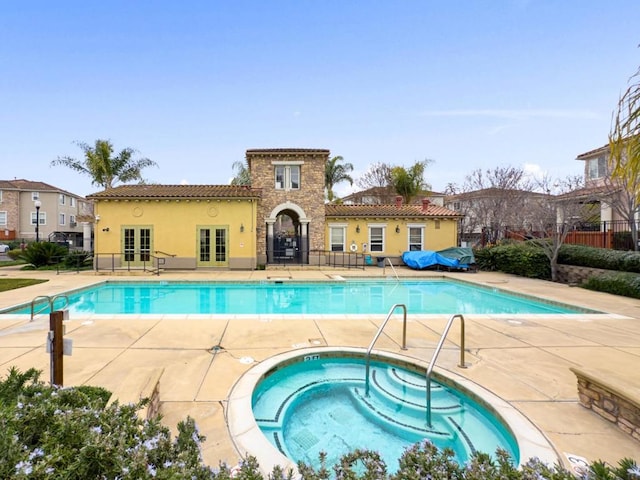 view of pool with a patio, a community hot tub, and french doors