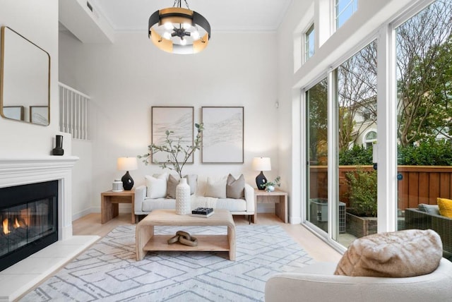 interior space with crown molding, light hardwood / wood-style flooring, and a towering ceiling