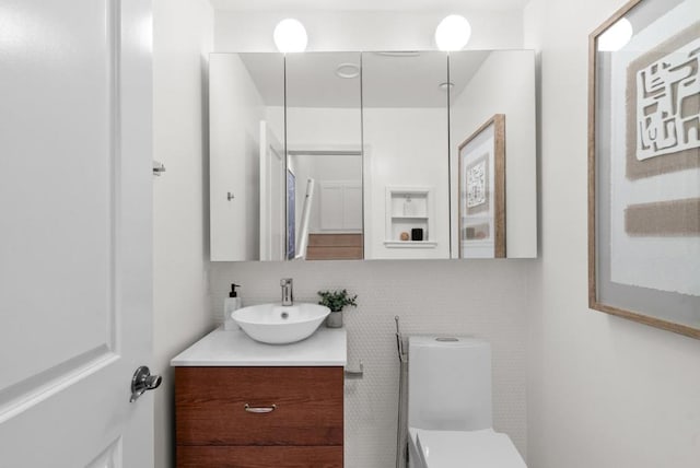 bathroom with vanity, decorative backsplash, and toilet