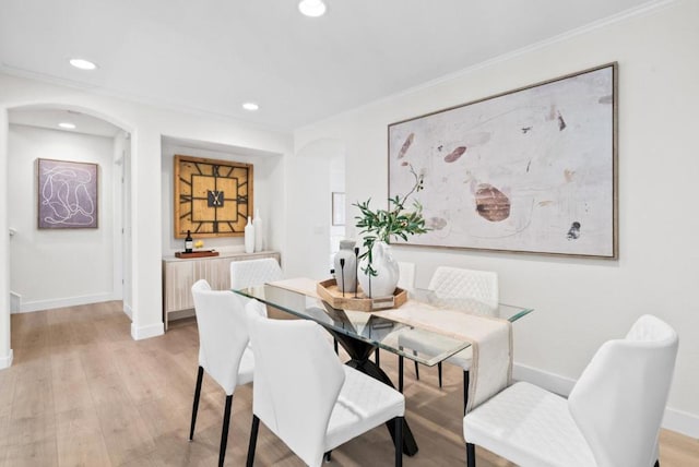 dining room featuring ornamental molding and light wood-type flooring