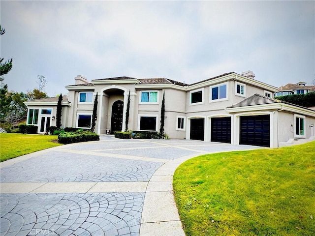 view of front of property with driveway, a chimney, an attached garage, and stucco siding