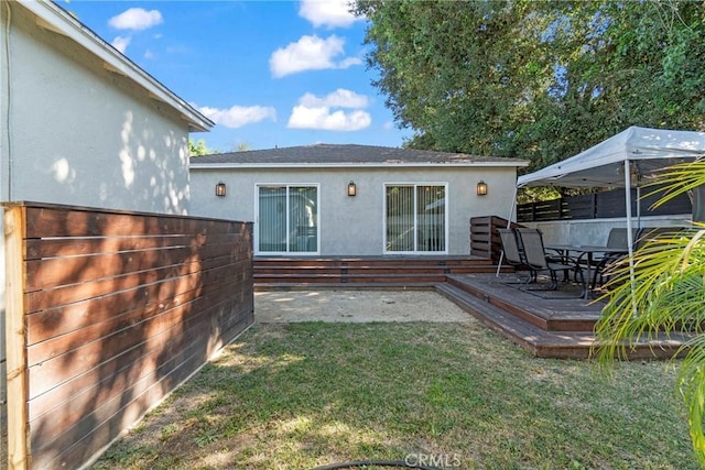 back of house with a wooden deck and a yard