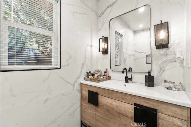 bathroom featuring vanity and tile walls