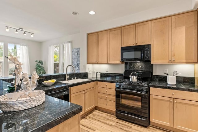 kitchen featuring sink, light hardwood / wood-style flooring, black appliances, light brown cabinetry, and kitchen peninsula