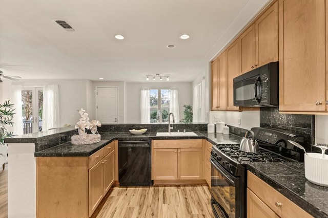 kitchen with sink, backsplash, light hardwood / wood-style floors, black appliances, and kitchen peninsula