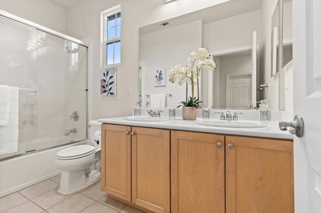 full bathroom featuring vanity, tile patterned floors, shower / bath combination with glass door, and toilet