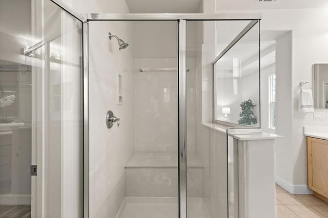 bathroom with vanity, a shower with shower door, and tile patterned flooring