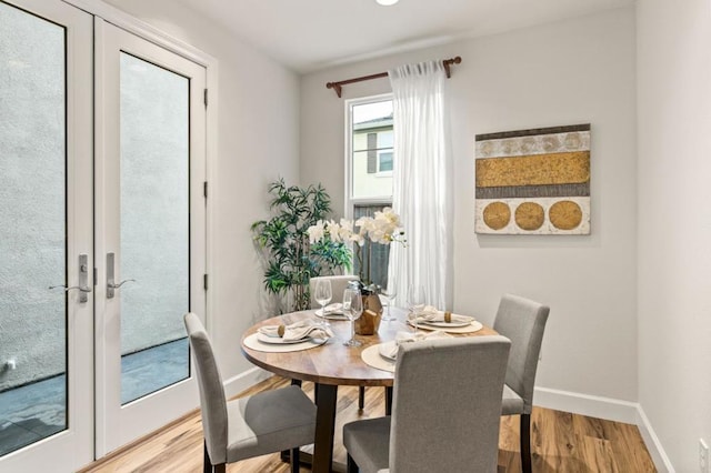 dining area with hardwood / wood-style floors and french doors