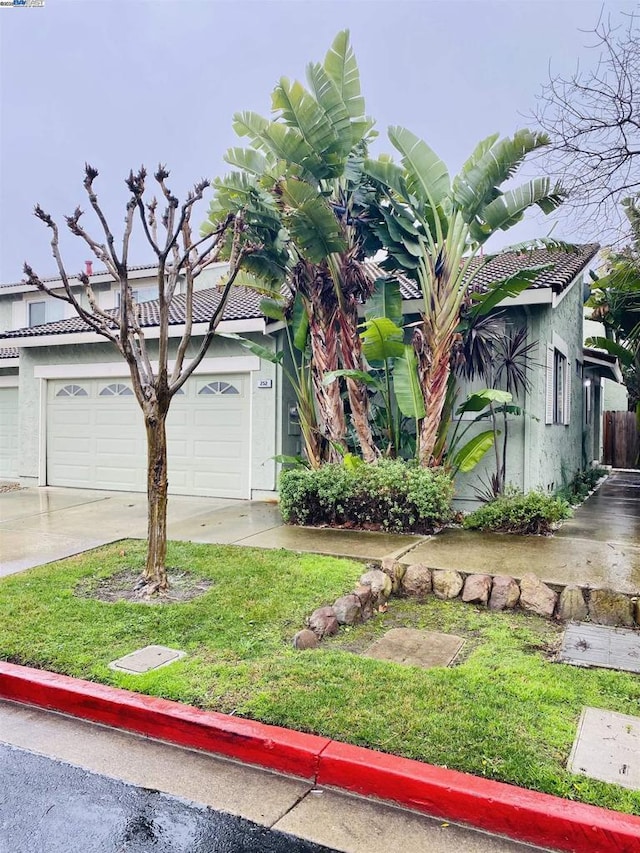 view of front of property with a garage and a front lawn