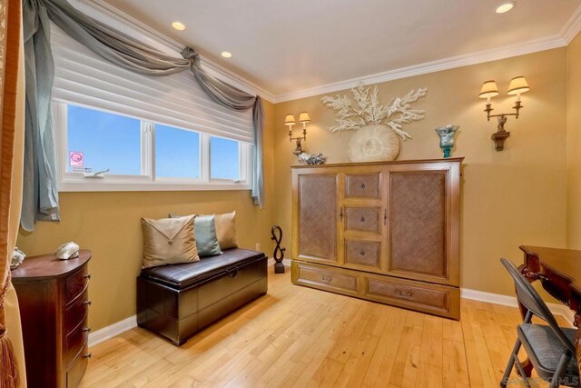 living area with crown molding and light hardwood / wood-style floors