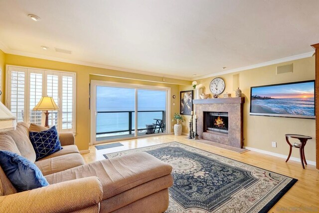 living room with crown molding, a high end fireplace, and wood-type flooring