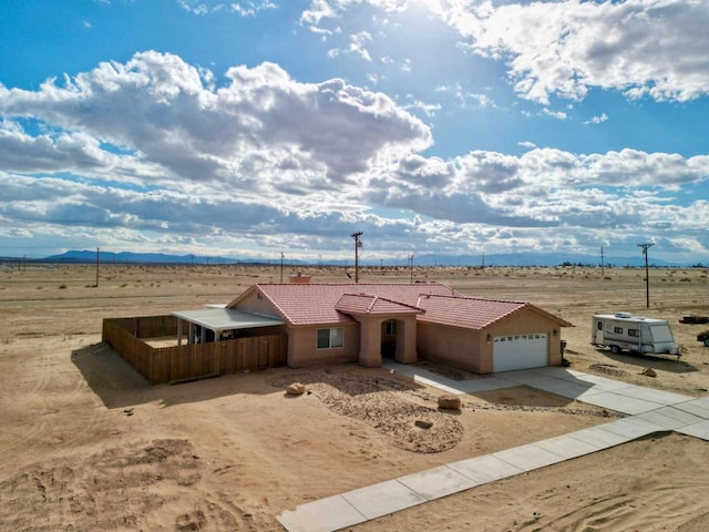 view of front of property with a garage and a rural view