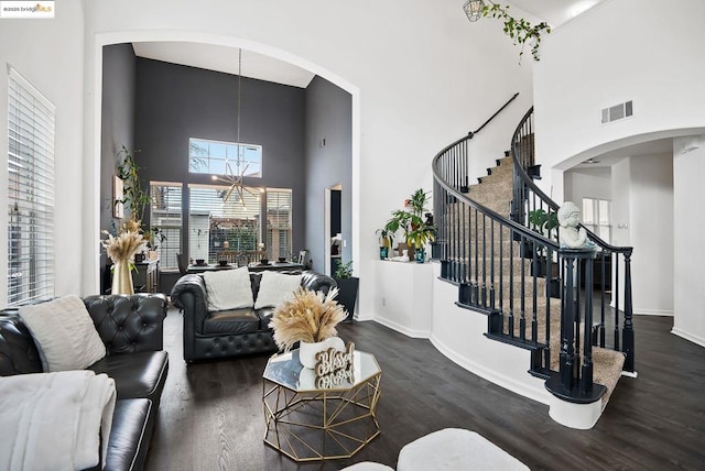 living room with dark hardwood / wood-style floors, a chandelier, and a high ceiling