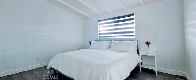 bedroom featuring dark wood-type flooring and vaulted ceiling with beams