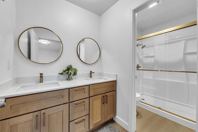 bathroom featuring walk in shower, vanity, toilet, and wood-type flooring