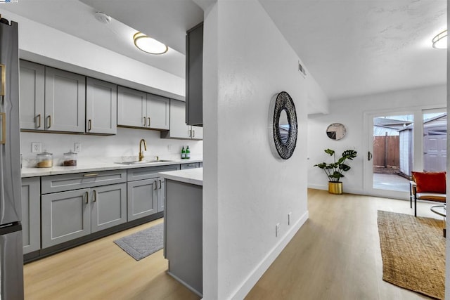 kitchen featuring gray cabinets, sink, and light hardwood / wood-style flooring