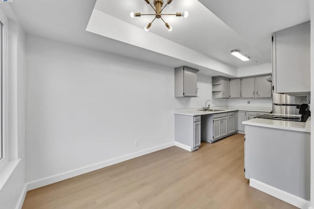 kitchen featuring gray cabinetry, sink, and light wood-type flooring