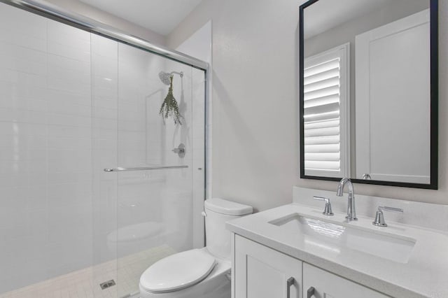 bathroom with vanity, toilet, and a shower with shower door