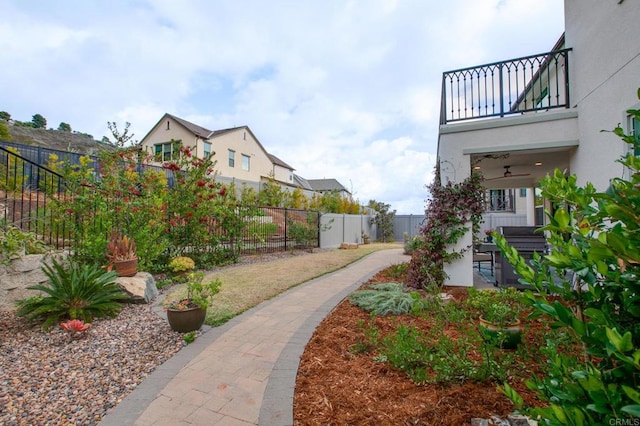 view of yard with ceiling fan and a balcony