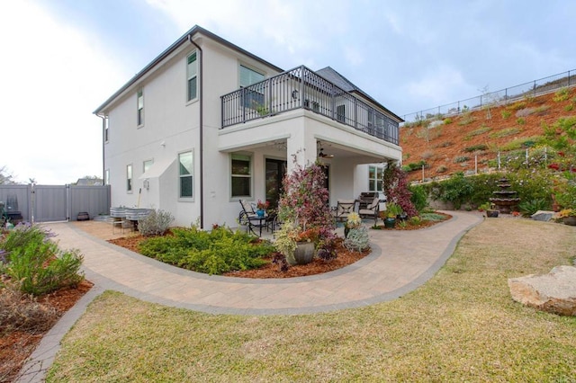 back of house with a yard, a patio area, and a balcony