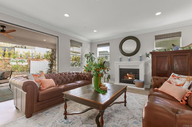 living room featuring crown molding, light wood-type flooring, and ceiling fan