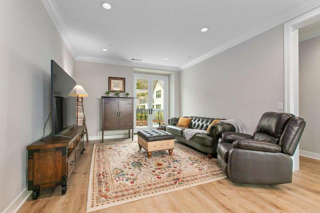 living room featuring crown molding, french doors, and light wood-type flooring