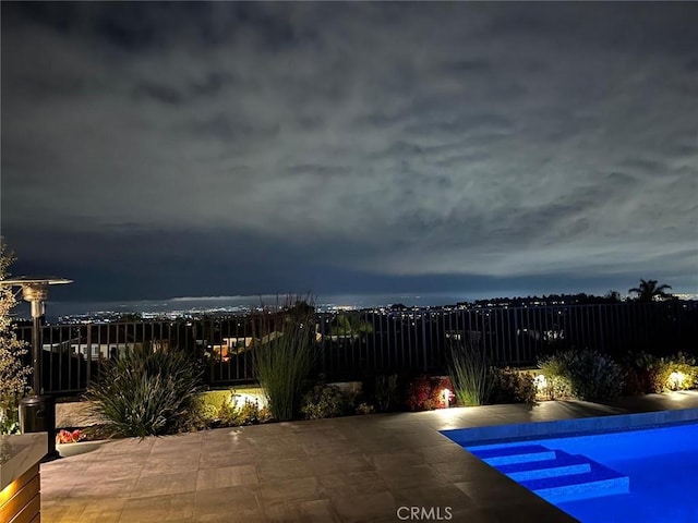 pool at twilight featuring a patio area