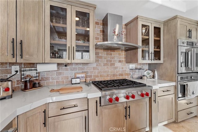 kitchen with tasteful backsplash, stainless steel appliances, wall chimney exhaust hood, and light brown cabinets