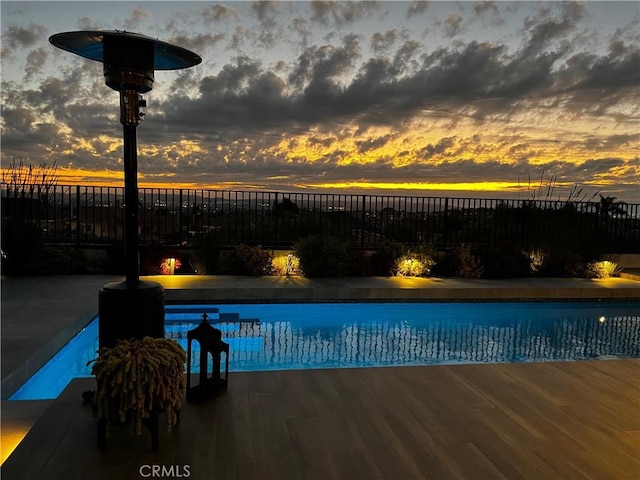 pool at dusk with a patio