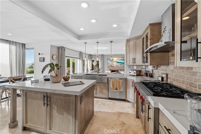 kitchen featuring sink, dishwasher, backsplash, decorative light fixtures, and wall chimney exhaust hood