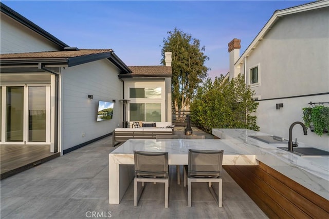 patio terrace at dusk with sink and outdoor lounge area