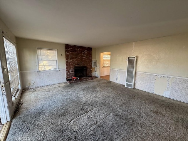 unfurnished living room featuring carpet flooring and a fireplace