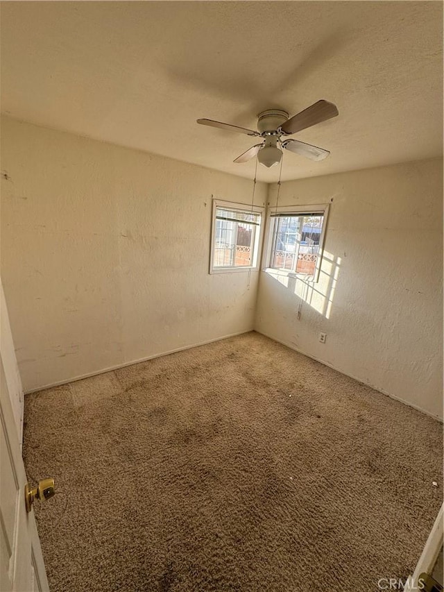 carpeted empty room featuring ceiling fan and a textured ceiling