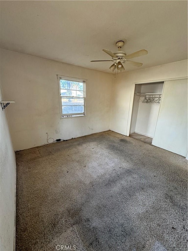 unfurnished bedroom featuring carpet, ceiling fan, and a closet