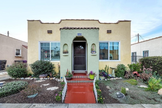 view of exterior entry featuring fence and stucco siding