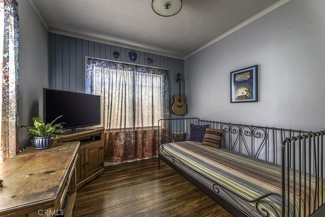 bedroom with dark wood finished floors and crown molding