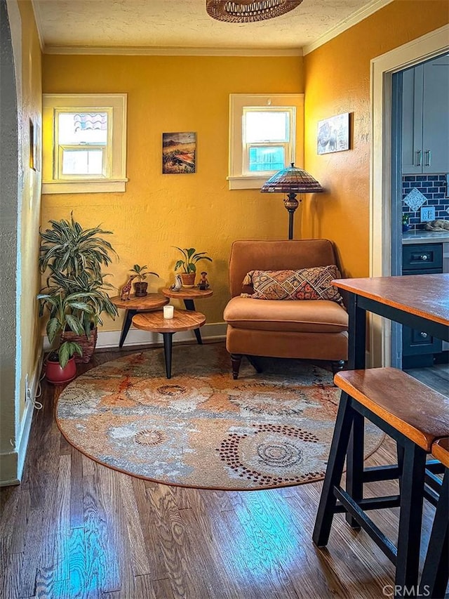 living area with plenty of natural light, wood finished floors, and crown molding