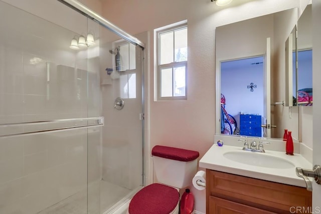 bathroom with vanity, toilet, and a shower with shower door