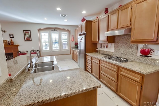 kitchen with light stone counters, appliances with stainless steel finishes, light tile patterned flooring, and sink