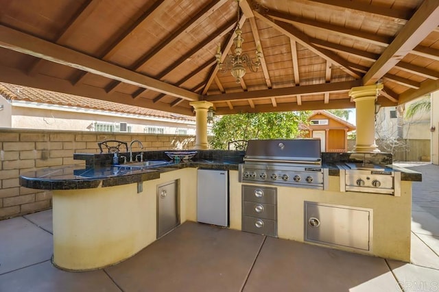 view of patio with exterior kitchen, a gazebo, sink, and grilling area