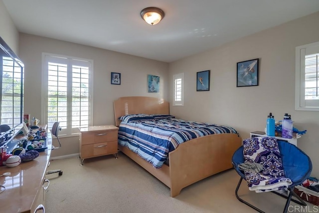 carpeted bedroom featuring multiple windows