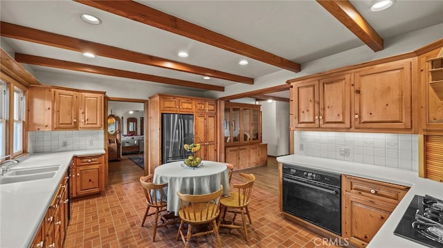 kitchen featuring sink, black appliances, a kitchen bar, decorative backsplash, and beamed ceiling